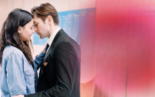 Pilot comforting refugee girl inside airport terminal in emotional love story